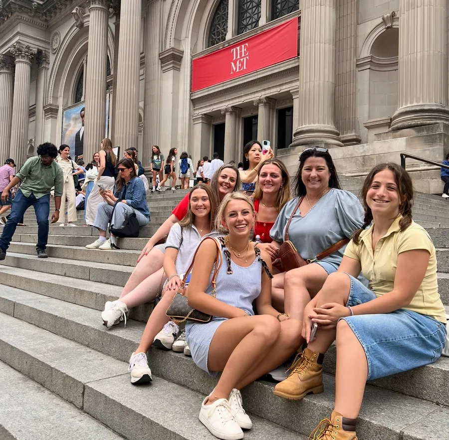 Gossip Girl Tours group smiling on the Met Steps under the red banner on the Exclusive Gossip Girl tour of the Upper East Side