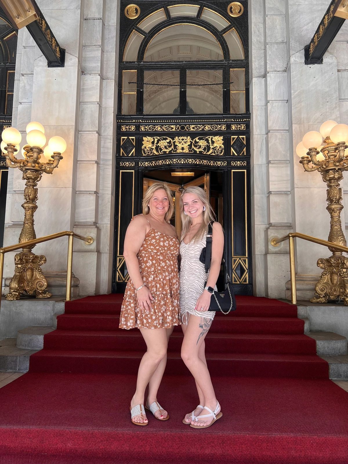 Two guests on the red carpet steps of the Lotte New York Palace on a Gossip Girl tour in New York City