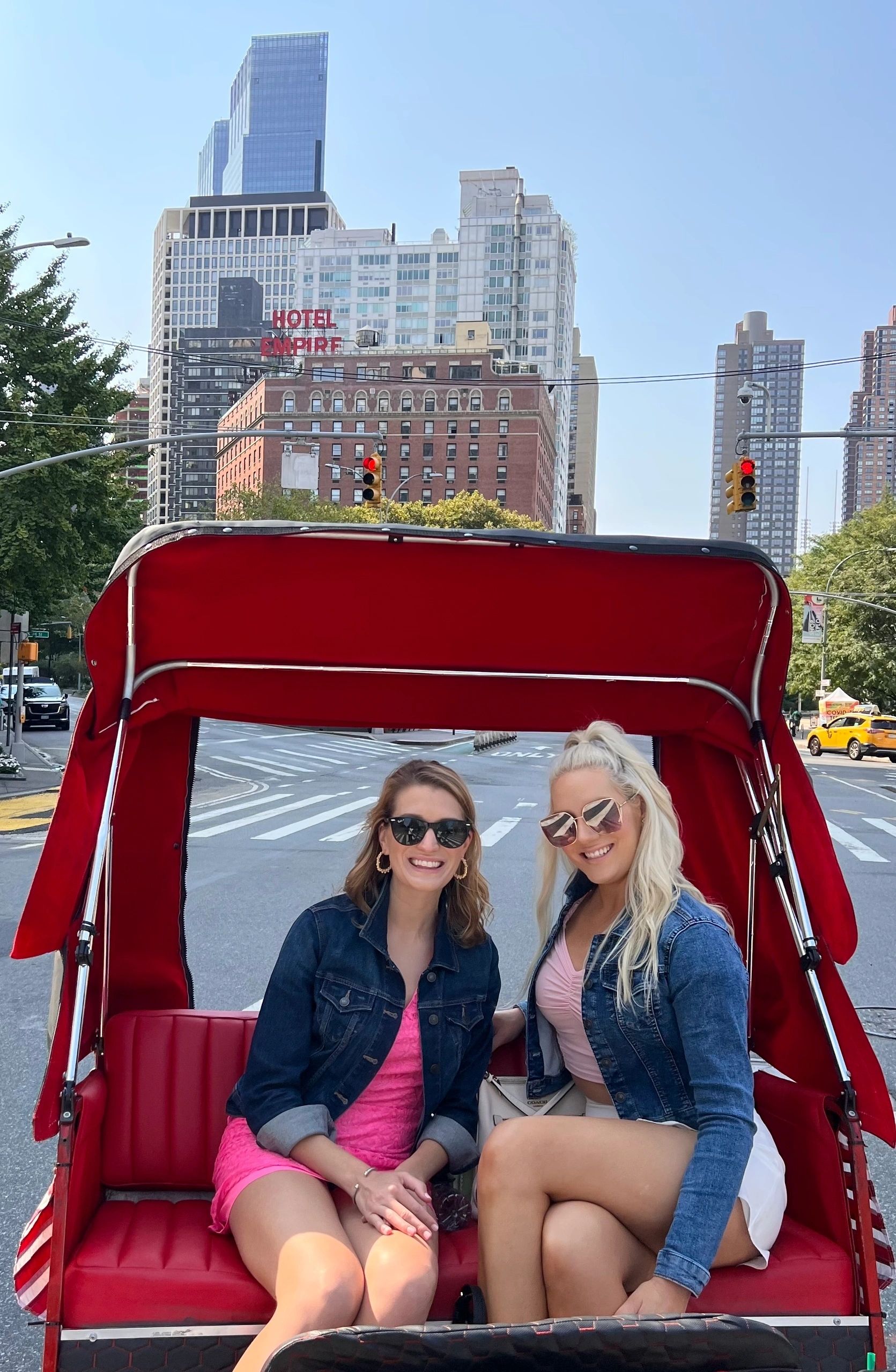 Two guests riding the XOXO pedicab on the Gossip Girl Experience NYC past Columbus Circle in Manhattan