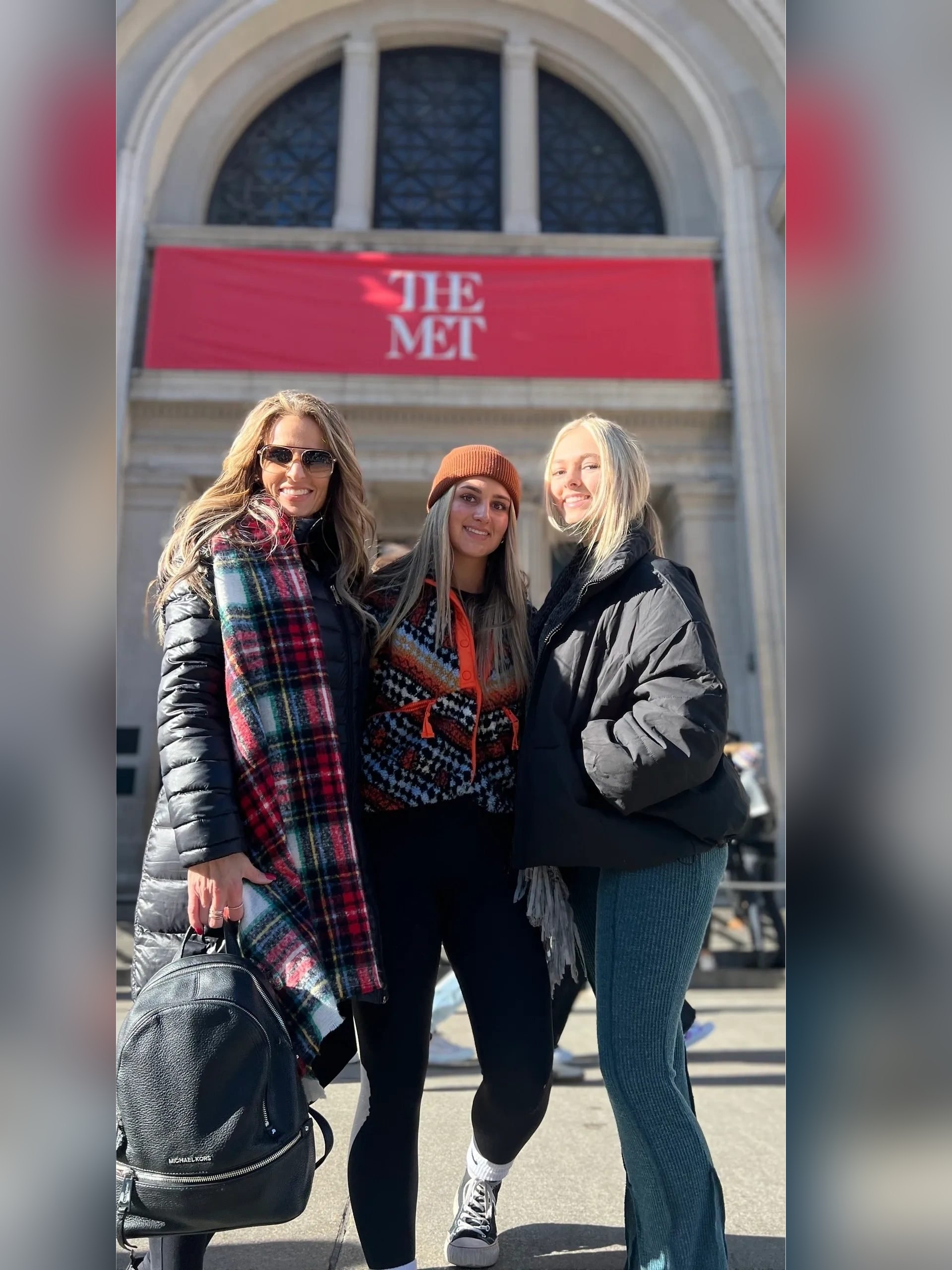 Three guests in front of The Met banners on Fifth Avenue on a Gossip Tour in New York City