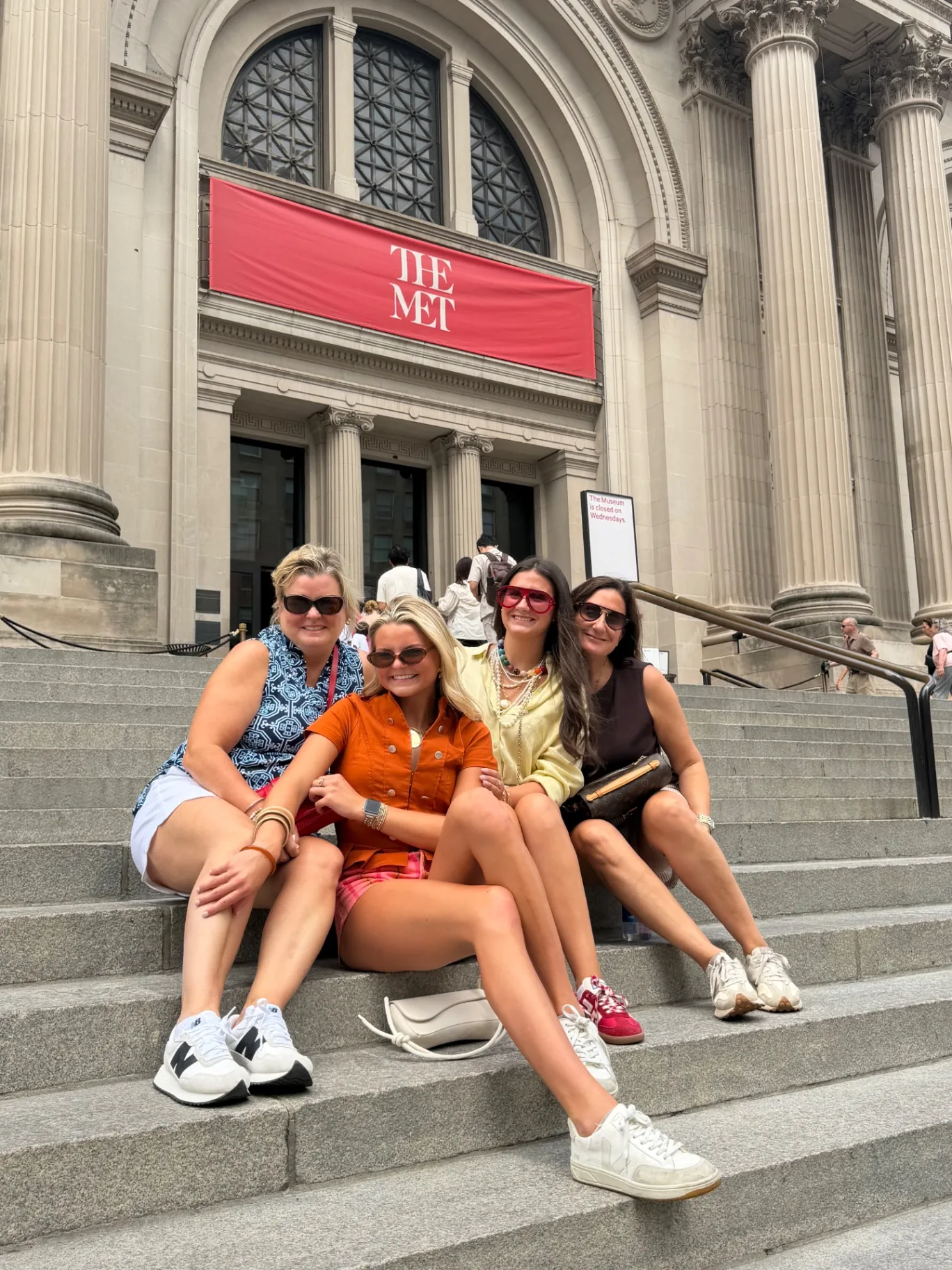 A family of four seated on the Met Steps on Fifth Avenue during a Gossip Girl tour of New York City